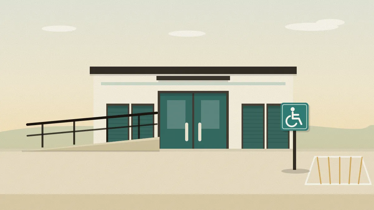 Flat illustration of a single-storey storage building with a wide teal double door under a canopy, a gently sloping ramp with a handrail leading up to it, a marked parking bay and a teal sign with the wheelchair symbol